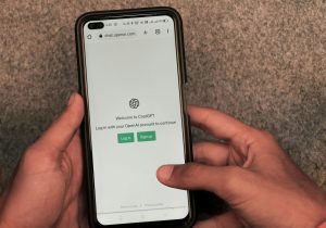User holding a smartphone displaying an AI assistant interface, representing AI customer discovery and modern search behavior
