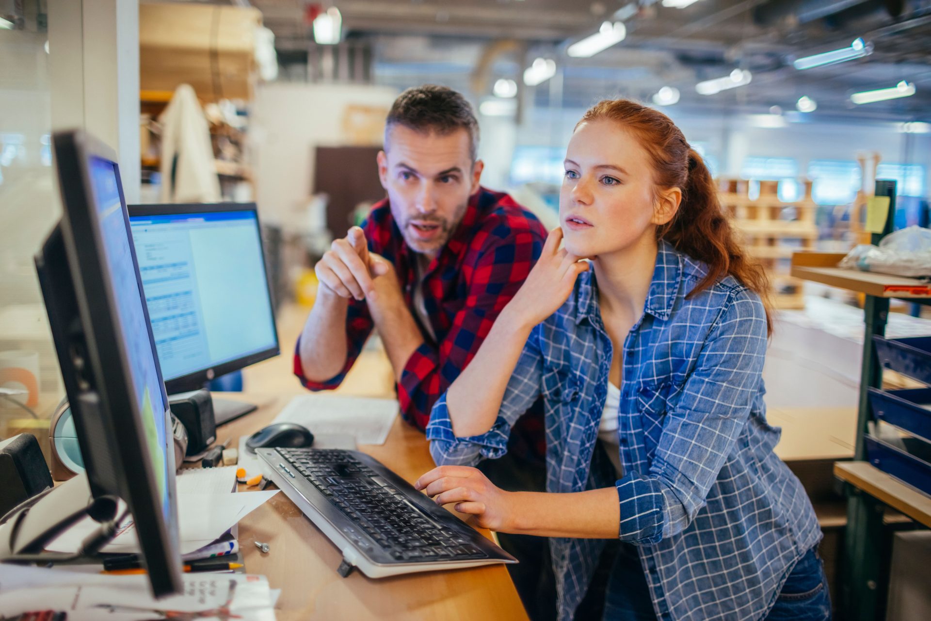 Two professionals collaborating at a computer to analyze AI search vs SEO data and bridge the prompt gap for JAR Consulting Group.